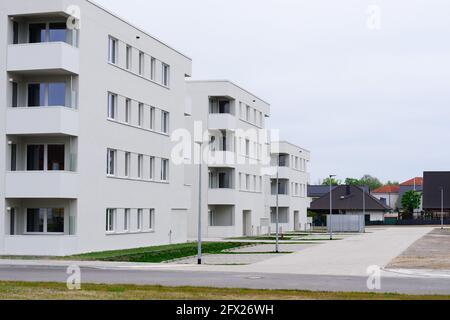 Oranienburg, Deutschland. Mai 2021. Die von der Oranienburger Wohnungsbaugesellschaft (WOBA) in der Weißen Stadt an der Emil-Büge-Straße/Ecke Walther-Bothe-Straße errichteten neuen mehrstöckigen Gebäude sind im Rohbau oder fast bezugsfertig. Im Hintergrund sind Einfamilienhäuser in der Johannes-Rau-Straße zu sehen. Quelle: Soeren Stache/dpa-zentralbild/dpa/Alamy Live News Stockfoto
