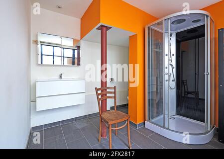 Bad und Dusche im Loft mit oranger Wand Stockfoto