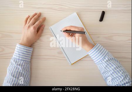 Kreativität und Inspiration Konzept. Weibliche Hände schreiben Plan in leerem Notizbuch, halten schwarzen Stift Stockfoto