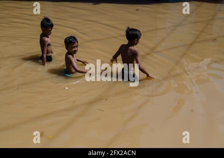 Bandung, Indonesien. Mai 2021. Kinder waten durch Flutwasser wegen des Überflusses des Citarum Flusses, in Bandung, West Java, Indonesien, Mai 25, 2021. Kredit: Septianjar/Xinhua/Alamy Live News Stockfoto