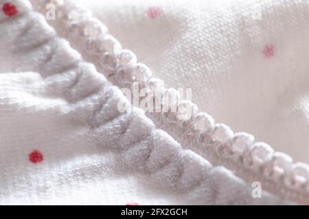 Weiße Kleidung mit roten Mustern und elastischem Band, Textur Stockfoto