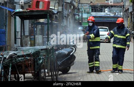 Guwahati, Indien. Mai 2021. Workers Spray Sanitizer at a Commercial Hub of Guwahati, India, 25. Mai 2021. Quelle: Str/Xinhua/Alamy Live News Stockfoto