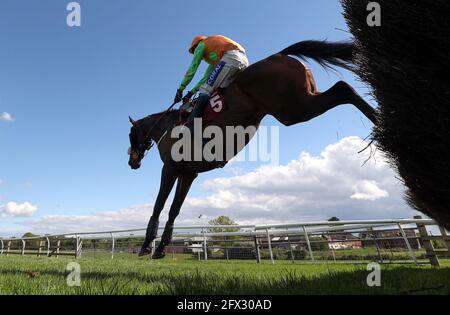 Loch Garman Aris wird von dem Jockey Tom Scudamore gefahren, um auf dem Weg zum Gewinn der Tallarn Green Handicap Chase auf der Rennbahn Bangor-on-Dee einen Zaun zu räumen. Bilddatum: Dienstag, 25. Mai 2021. Stockfoto