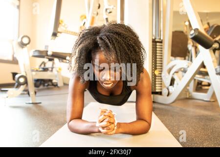 Schönes Mädchen in der Turnhalle. Sportliche Mädchen in Sportbekleidung Training, eine Person aus der Nähe, schwarze Frau, afroamerikaner, natürliche Haare, Hintergrund, Fitness Stockfoto