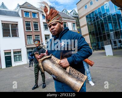 Den Haag, Niederlande. Mai 2021. Ein Mann aus West-Papua sah während der Demonstration ein traditionelles Instrument spielen. Kredit: SOPA Images Limited/Alamy Live Nachrichten Stockfoto