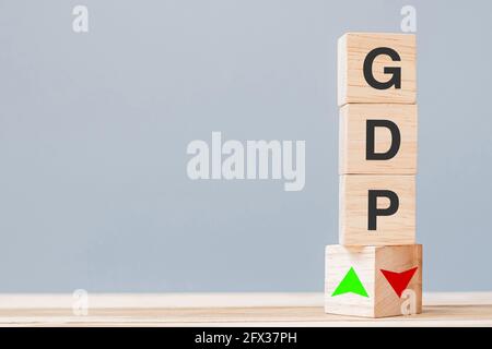 Holzwürfelblock mit GDP-Text (Bruttoinlandsprodukt) zu NACH OBEN und nach unten zeigenden Pfeilsymbolen. Finanz-, Management-, Wirtschafts- und Geschäftskonzepte Stockfoto