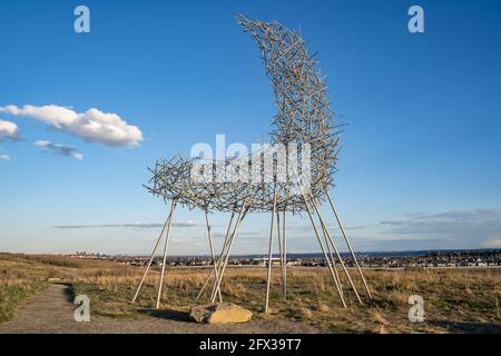 Calgary Alberta Kanada, 10 2021. Mai: Die Covergence-Ausstellung auf dem Rocky Ridge unter einem dramatischen Himmel in einer kanadischen Stadt. Stockfoto