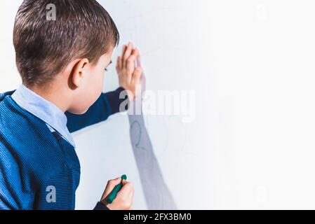 Schönes Kind zeichnet mit Buntstiften an die Wand Stockfoto