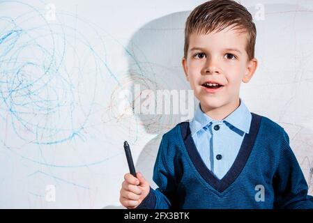 Schönes Kind zeichnet mit Buntstiften an die Wand Stockfoto