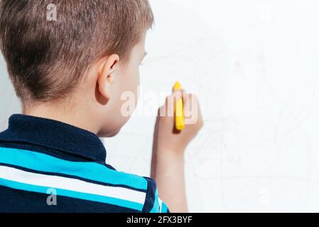 Schönes Kind zeichnet mit Buntstiften an die Wand Stockfoto