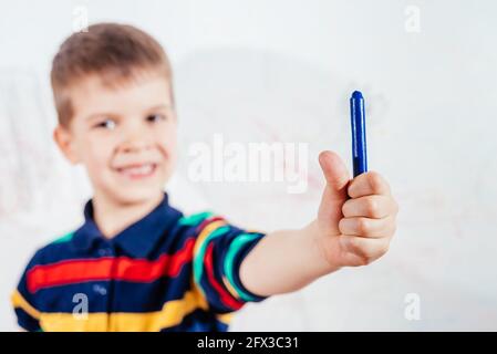 Schönes Kind zeichnet mit Buntstiften an die Wand Stockfoto