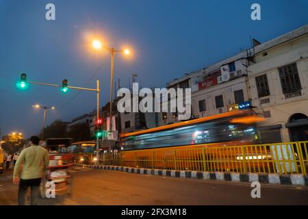 NEW DELHI, INDIEN - OKTOBER 28 2018 : Orange Bus fährt durch eine belebte Straße am Abend, Delhi hat eine der verkehrsreichsten Verkehr in ganz Indien. Stockfoto