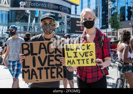 Black Lives Matters Protest auf dem Yonge-Dundas Square in Toronto, Kanada. Menschen, die Schilder halten und Schutzmasken tragen, wie es die Zeit des Cov ist Stockfoto