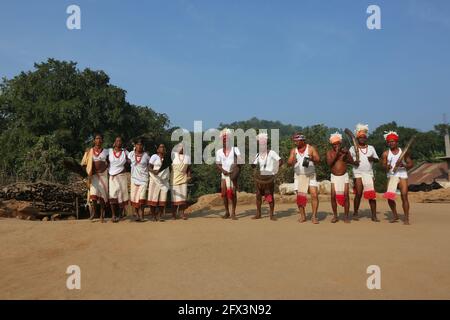 LANJIA SAORA TRIBE - traditioneller Gruppentanz. Männliche Tänzer mit Lendenschurzen und Köpfen, die mit weißen Vogelfedern verziert sind, spielen Trommeln, Gagerai, Trete Stockfoto