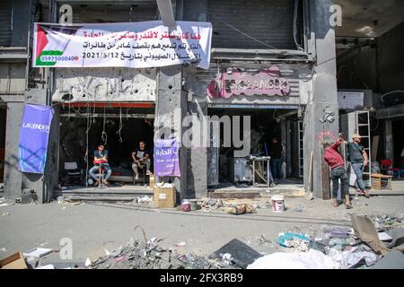 Gaza, Palästina. Mai 2021. Palästinenser sitzen nach den israelischen Streiks vor ihrem zerstörten Laden.der US-Spitzendiplomat Antony Blinken schwor Unterstützung beim Wiederaufbau des zerrütteten Gazastreifens und bei der Unterstützung eines Waffenstillstands zwischen der Hamas und Israel, bestand aber darauf, dass die militanten islamistischen Herrscher des Territoriums von keiner Hilfe profitieren würden. Kredit: SOPA Images Limited/Alamy Live Nachrichten Stockfoto