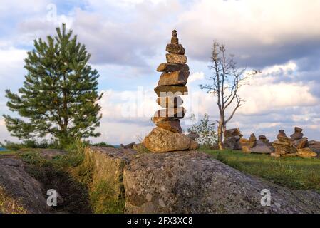 Steinpyramide aus der Nähe. Ein touristisches Symbol auf dem Gipfel des Berges Paasonvuori an einem bewölkten Augustabend. Karelien, Russland Stockfoto