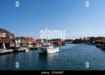 17. April 2021 - Hamburgsund, Schweden: Ein malerisches Fischerdorf an der schwedischen Westküste. Traditionelle Hütten am Roten Meer und ein blauer Himmel im Hintergrund Stockfoto