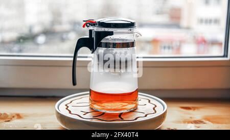 Teekannen aus Kunststoff-Glas mit Knopf und Kolben zum Brühen von Tee Brühen Stockfoto