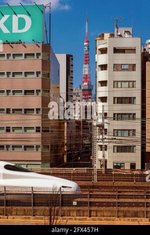 Ein Shinkansen, der berühmte japanische Hochgeschwindigkeitszug, fährt durch die Stadt und ist nicht weit vom berühmten Tokyo Tower entfernt Stockfoto