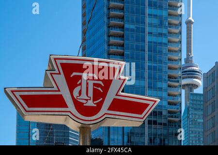 Ein TTC oder Toronto Transit Commission Schild mit dem CN Tower und anderen modernen Wolkenkratzern im Hintergrund, Kanada Stockfoto