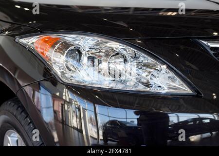 Neue moderne unbekannte Auto mit eleganten Scheinwerfer. Zugeschnittenes Bild. Nahaufnahme. Moderne Verkehrsmittel. Stockfoto