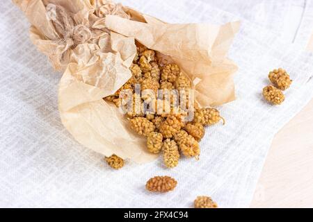 Getrocknete süße natürliche Maulbeerbeeren auf hellem Hintergrund in der Küche. Stockfoto