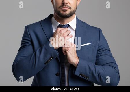 Selbstbewusster professioneller Geschäftsmann, der das Krawatte-Konzept anpasst Stockfoto