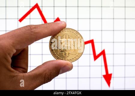 Barcelona, Spanien. Mai 2021. In dieser Abbildung ist ein Bitcoin mit einer Grafik im Hintergrund zu sehen. (Foto von Thiago Prudencio/SOPA Images/Sipa USA) Quelle: SIPA USA/Alamy Live News Stockfoto