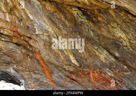 Nahaufnahme von schrägen mehrfarbigen Gesteinsschichten an der Küste Der Lizard in Cornwall, großbritannien Stockfoto