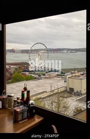 Seattle Big Wheel vom Pike Market Restaurant. Downtown Seattle Big Wheel an einem grauen Tag. Das Riesenrad ragt entlang der Küste hervor. Stockfoto