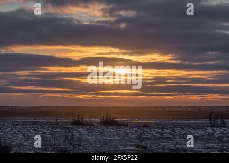 Ein atemberaubender, wolkig verwitterter Sonnenuntergang auf den Tundra-Ebenen im Norden von Manitoba, Churchill im Eisbärland. Stockfoto