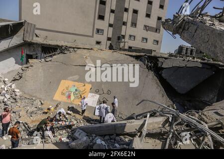 Gaza, Palästina. Mai 2021. Palästinensische Künstler malen Wandmalereien auf eingestürzte Gebäude nach den israelischen Streiks in Gaza. DER US-Spitzendiplomat Antony Blinken schwor Unterstützung beim Wiederaufbau des zerrütteten Gazastreifens und bei der Unterstützung eines Waffenstillstands zwischen der Hamas und Israel, bestand aber darauf, dass die militanten islamistischen Herrscher des Territoriums von keiner Hilfe profitieren würden. (Foto von Mahmoud Issa/SOPA Images/Sipa USA) Quelle: SIPA USA/Alamy Live News Stockfoto