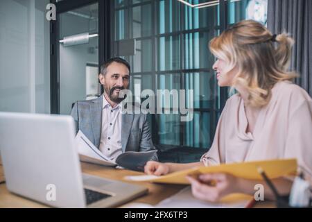 Bärtiger Mann und blonde Frau studieren Papiere Stockfoto