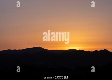 Bergsilhouette bei Sonnenuntergang in der Nähe von Almogia Dorf, Malaga, Spanien Stockfoto