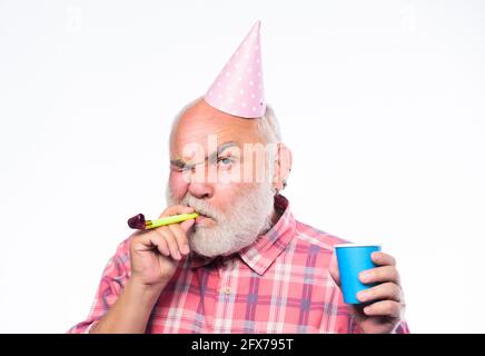 Großvater Graubart weht Party Pfeife. Älter zu werden macht immer noch Spaß. Ältere Menschen. Geburtstagskonzept. Ideen für Seniorengeburtstage Stockfoto