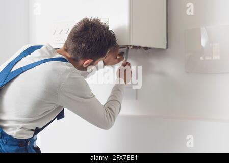 Professioneller Installateur, der einen Kessel und Rohre überprüft, Kesselservicekonzept Stockfoto
