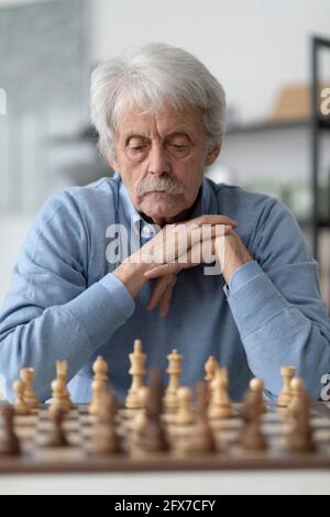 Älterer Mann, der Schach spielt, übt sein Gedächtnis aus Stockfoto