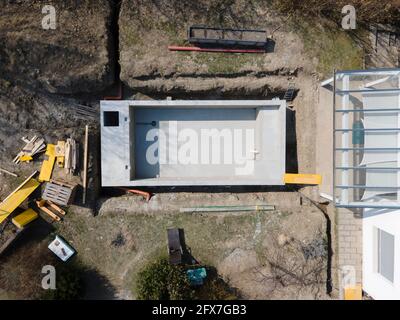 Drohnenaufnahme der Poolbaustelle, auf der der Pool bereits fertig gefüllt, ohne Folie verputzt in einem Garten in österreich ist Stockfoto