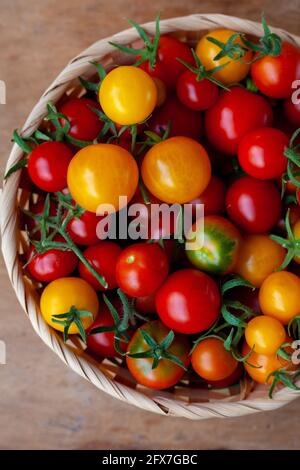 Rote und gelbe Kirschtomaten Schüssel Draufsicht. Gemüse ernten. Tomate auf dem Tisch. Vitamin gesunde Lebensmittel. Rustikale Küche. Stockfoto