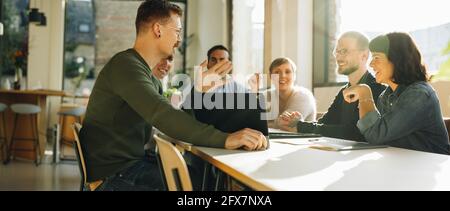 Kreatives Team, das sich zum Austausch neuer Ideen trifft. Männer und Frauen diskutieren über Startup-Unternehmen. Stockfoto