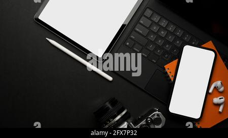 Kreativer, flacher Arbeitsplatz mit digitalem Tablet, Smartphone, Kamera, Notebook, Zubehör und Kopierbereich, Abschneideweg Stockfoto