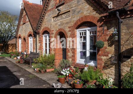 Die Exerzitien, eine Terrasse von historischen Armenhäuser stammt aus dem Jahr 1892, in einem Hinterhof an der High Street, Stony Stratford, UK eingestellt Stockfoto