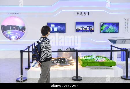 (210526) -- GUIYANG, 26. Mai 2021 (Xinhua) -- EINE Frau besucht den Ausstellungsbereich des fünfhundert Meter langen Aperture Spherical Radio Telescope (FAST) auf der China International Big Data Industry Expo 2021 in Guiyang, südwestlich der Provinz Guizhou, am 26. Mai 2021. Hier wurde am Mittwoch die China International Big Data Industry Expo 2021 eröffnet, auf der modernste wissenschaftliche und technologische Innovationen und Errungenschaften auf dem jeweiligen Gebiet vorgestellt wurden. Unter dem Motto „Umarmung digitaler Intelligenz, Bereitstellung neuer Entwicklungen“ ist die diesjährige expo sowohl online als auch offline geplant. Die expo will witnes Stockfoto