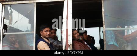 Männer aus Bangladesch sitzen in einem öffentlichen Bus in Dhaka, Bangladesch. Stockfoto