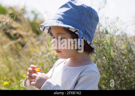 Junge Kleinkind Mädchen spielen im Freien, allein in der Natur Stockfoto