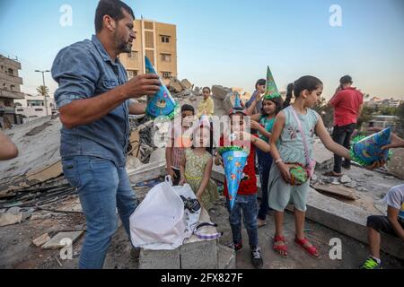 Gaza-Stadt. Mai 2021. Raed Sobeih feiert in den Trümmern seines Hauses, das durch die israelische Bombardierung zerstört wurde, den Geburtstag von Muhammads Tochter. Kredit: Majority World CIC/Alamy Live Nachrichten Stockfoto