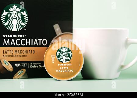 Starbucks Latte Macchiato Kaffeekapseln Box neben weißer Tasse Kaffee und Kapsel Latte Macchiato auf grünem Hintergrund Stockfoto