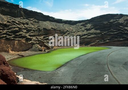 Schöner grüner See mit großen Felsen in El Golfo Spanien unter blauem Himmel Stockfoto