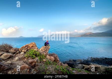 Con Dao Island in der Provinz Ba Ria-Vung Tau, Vietnam - 11. April 2021: Freie Reise Frau meditiert Entspannung auf der Bergspitze in Con Dao Insel und Stockfoto