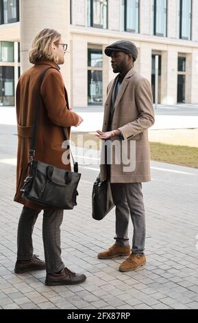 Zwei junge Männer stehen draußen und sprechen miteinander Stockfoto